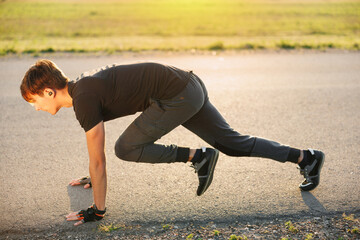 Rear view of an athlete starting his sprint on an all-weather running track