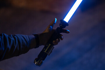 Man holding Lightsaber with blue emitted blade