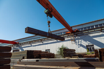 Fototapeta na wymiar Gantry crane transporting stack of metal pipes