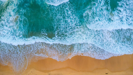 Obraz premium Beautiful sea waves and white sand beach in the tropical island. Soft waves of blue ocean on sandy beach background from top view from drones. Concept of relaxation and travel on vacation.