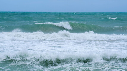 Beautiful ocean waves with blue and turquoise foam on a hot summer day.