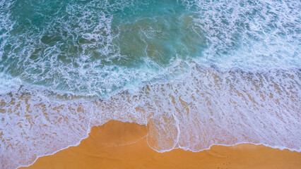 Fototapeta na wymiar Beautiful sea waves and white sand beach in the tropical island. Soft waves of blue ocean on sandy beach background from top view from drones. Concept of relaxation and travel on vacation.