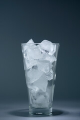 Glass tumbler with ice on a dark background, still life