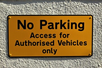 No Parking sign - yellow with black lettering. Access for authorized vehicles only
