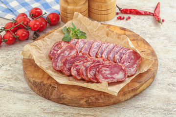 Sliced salami sausages over board