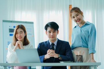 A group of cheerful modern Asian businessmen working together. Sit at a table discussing new project discovery solutions to increase effective communication ideas. chart on whiteboard