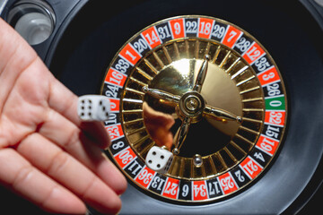 Mano femenina lanzando dados y girando ruleta, concepto de casino juegos de azar