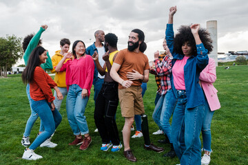 Group of young people from different cultures dancing and enjoying free time outdoors