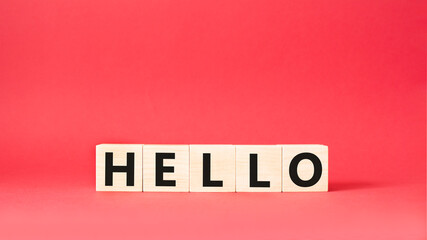 Hello symbol. Wooden cubes with word Hello. Beautiful red background. Hello concept. Copy space.
