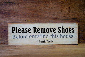Close up wooden sign please remove shoes sign