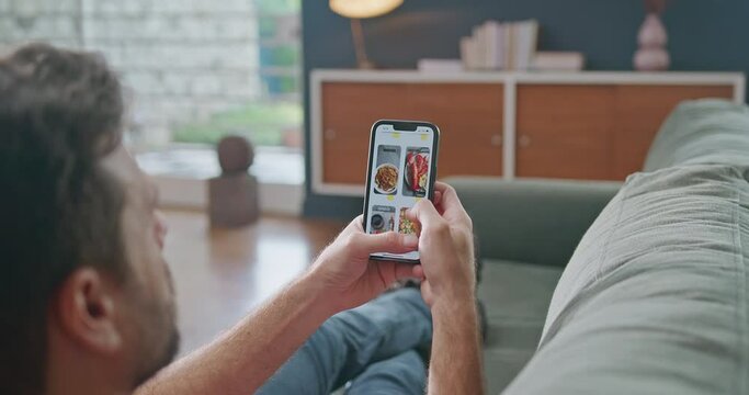 Man scrolling online menu browsing food on delivery app. Person holding cellphone scrolling food to order