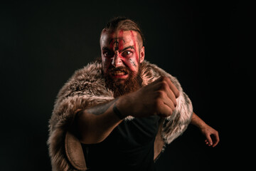 Fototapeta premium Angry Viking warrior with war paint, attacking his foe in anger and rage