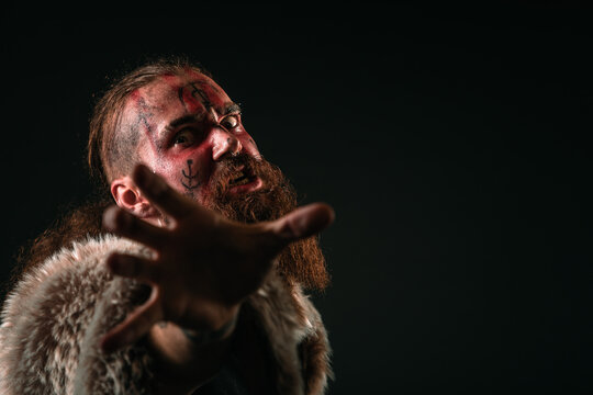 Mad Viking warrior with war paint, extending his hand and attacking