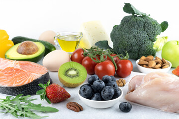 Assortment of products for the ketogenic diet: green vegetables, salmon, meat, eggs, berries,...