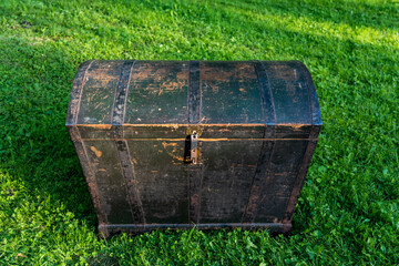 An old wooden chest outside with metal hoops.