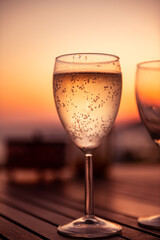 Traditional house white wine served in tavern, traditional greece drink, mazing sunset as background