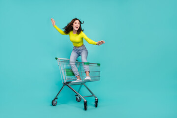 Full body portrait of crazy positive lady stand inside shopping cart ride empty space isolated on...
