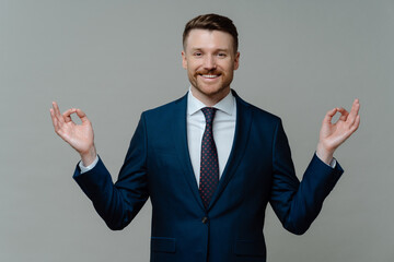 Happy businessman in suit meditating and feeling peaceful
