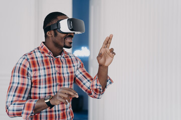 Naklejka premium African american guy in virtual reality glasses test purchase in online store. Ecommerce, cyberspace