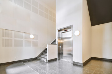 Shiny elevator with opened door located in illuminated hall of contemporary apartment building with...