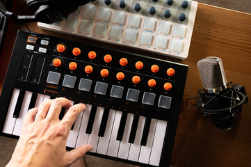 MIDI keyboard and human hand. Professional studio equipment. Recording studio, music studio, radio....