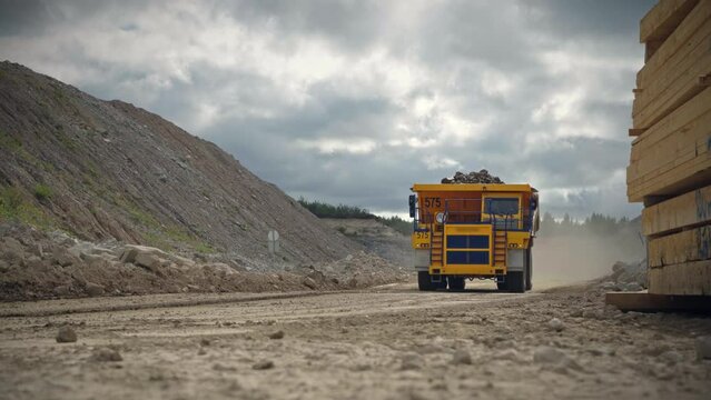 Large quarry dump truck in a coal mine. Loading coal into body work truck. Mining equipment for the transportation of minerals.
