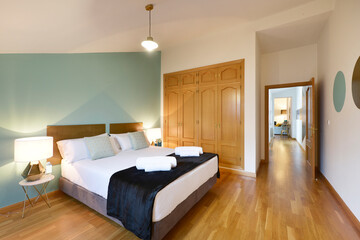 Bedroom with double bed, marble and metal nightstands, built-in wardrobe with oak sliding doors,...