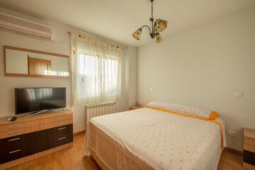 Bedroom with double bed, wooden tables to match the chest of drawers and flat screen TV