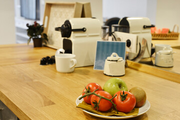 Dining room wooden tables with matching chairs and counters with fruits and vegetables