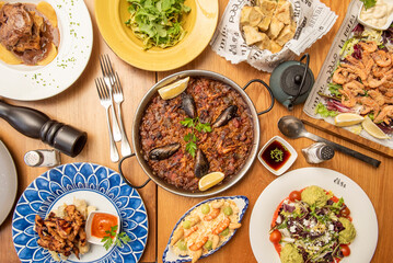 Dishes and starters of Spanish gastronomy recipes with tapas of fried prawns, a seafood paella with mussels, Russian salad with good prawns and some salads to degrease