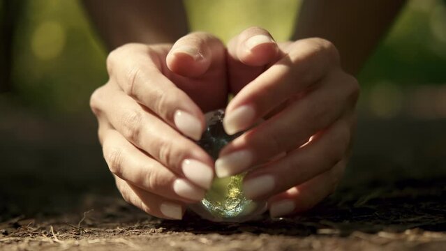 Human hands cover a glass globe.Earth Day, Save Planet, Save the world, Love Nature.