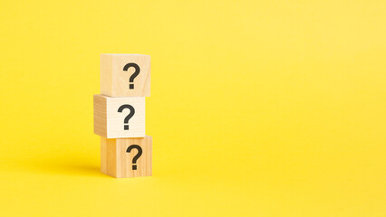 question mark shown on three wooden cubes on a yellow background