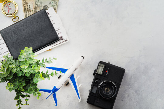 Creative composition. Planning a trip, vacation, vacation. Airplane, passport, money, camera on a white background. There are no people in the photo. There is free space to insert.