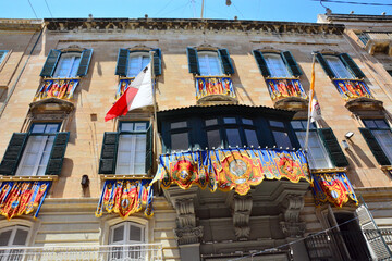 Colorful decoration, banners on building facade in old city of Valletta, Malta