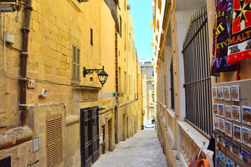 Valletta, Malta, Narrow street with historic sand-colored houses in capital city of Valletta.