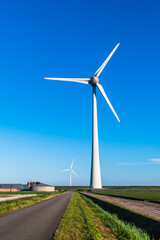 Wind turbine behind the dyke of the IJsselmeer on a summer day