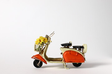 Retro skooter with flowers, vintage toy with yellow bouquet