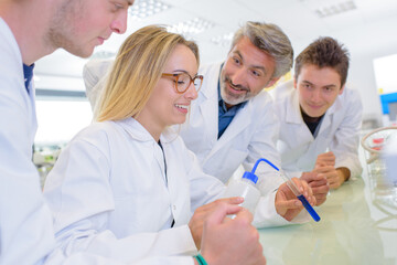 Students joking with teacher while carrying out experiment