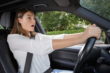 Naklejka premium young shocked woman while driving car