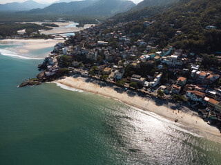 Fototapeta premium Aerial view of Barra de Guaratiba, west zone of Rio de Janeiro, Brazil. Next to Marambaia beach. Big hills around. Sunny day at dawn. Beach with clear water. Barra de Guaratiba beach. Drone photo
