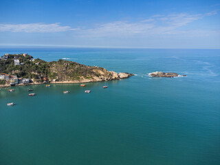 Fototapeta premium Aerial view of Barra de Guaratiba, west zone of Rio de Janeiro, Brazil. Next to Marambaia beach. Big hills around. Sunny day at dawn. Beach with clear water. Barra de Guaratiba beach. Drone photo
