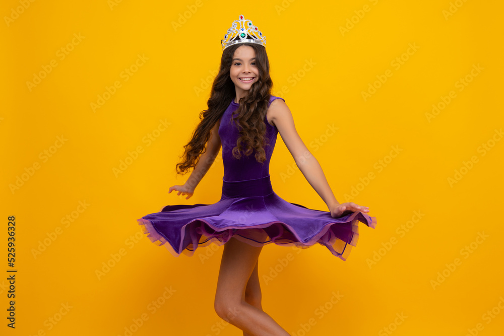 Wall mural movement windy dress. teen child in queen crown isolated on yellow background. princess girl in tiar