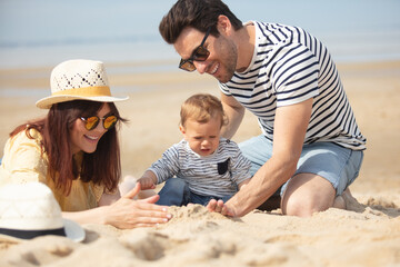 family with little boy playing on the beach