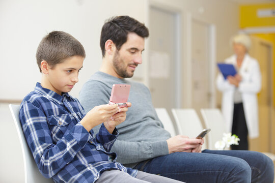 father  son waiting in room at clinic