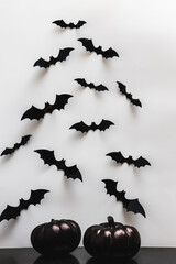 Black pumpkins and bat silhouettes on the white wall