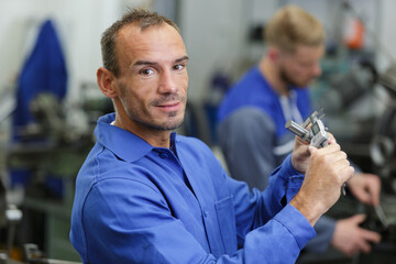 portrait of male engineer measuring with calliper