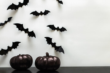 Black Halloween pumpkins and bat silhouettes on the white wall