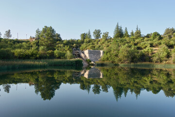Fototapeta na wymiar reflection of an old dam in the lagoon