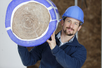 caucasian construction worker with roll of insulating material