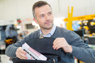 businessman putting white paper in blue file document
